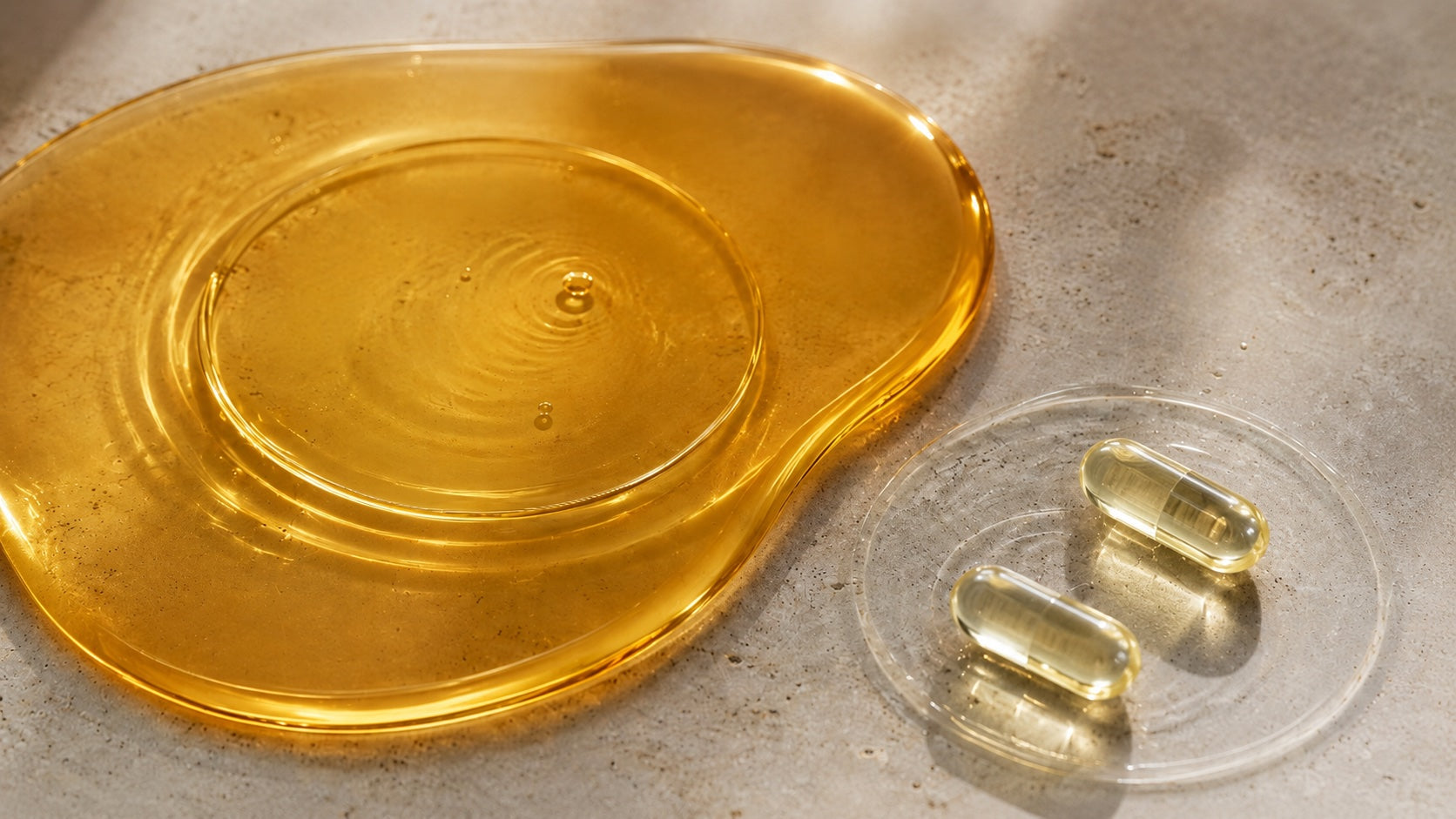 Goldenes Öl und zwei transparente HPMC Liquid-Caps visualisieren die Balance zwischen Omega-6 und Omega-3.